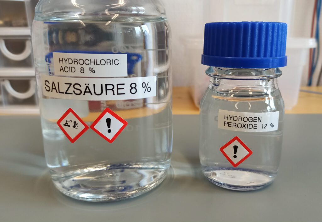 Zwei GL45 Laborflaschen mit 8 %-iger Salzsäure (links) und 12 %-igem Wasserstoffperoxid (rechts)