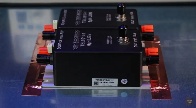 Zwei TekBox TBL0510-1-LISNs mit 5 µH, mittels selbstklebendem, kupferbeschichtetem Abschirmband fest mit der Referenzmassefläche verbunden; der werksseitig installierte 1-µF-Kondensator im LISN der Rückleitung (rechts) ist hier noch nicht entfernt